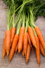 Fresh and sweet carrot on a grey wooden table.