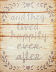 and they lived happily ever after - stock phrase for ending oral narratives or fairytale on a vintage wooden rustic background. DIY decoration