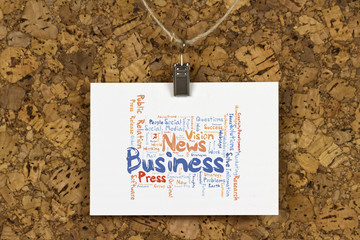 Business News word cloud on business card pinned up on cork board