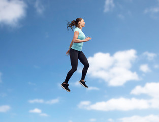 happy smiling sporty young woman jumping in air