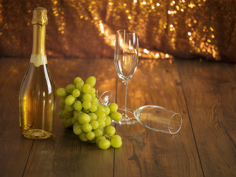 Still-life: Bottle of champagne, grapes, and two champagne glasses.