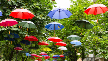 Street decorated with opened hanging colorful umbrellas