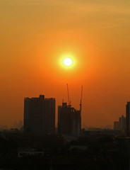 Naklejka premium Stunning sunset over the constructing buildings at the Suburbs of Bangkok, Thailand, vertical image 