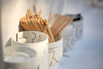 wooden drink stirrers in holder on table