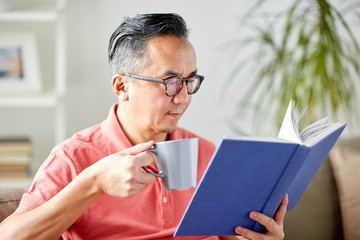 man sitting on sofa and reading book at home