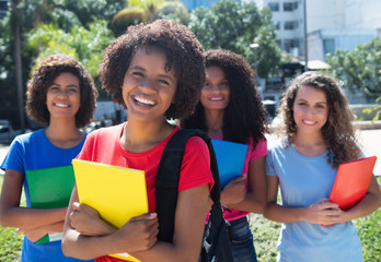 Fototapeta na wymiar Happy african american student with small group of latin and caucasian girls