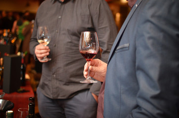 Men holding glasses with wine and toast