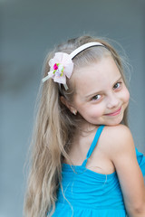 small baby girl with smiling face in blue dress outdoor
