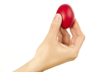 Unrecognizable woman hand holding up for egg knocking a red Easter egg.Ready for egg tapping. Happy Easter! Isolated on white background. 