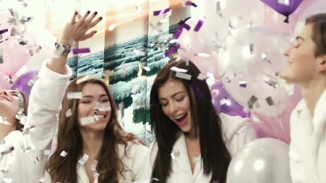 Beautiful girls in white robes celebrating at the opening party. Women having fun at the beauty salon