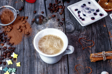 Cup of hot black coffee on a gray wooden surface