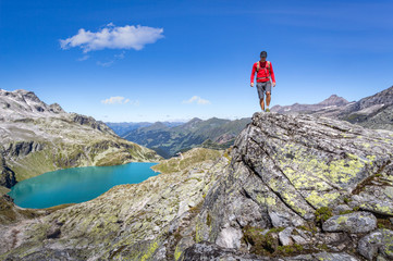 Mountaineer hiking over a rock in the alps