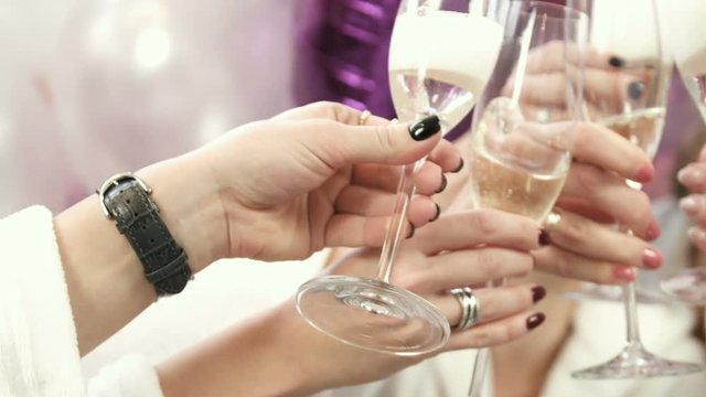 Close up view of girls opening champagne bottle. Drinking champagne at the party.