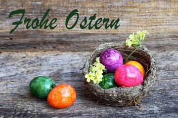 Frohe Ostern - Holzhintergrund mit bunten Ostereiern