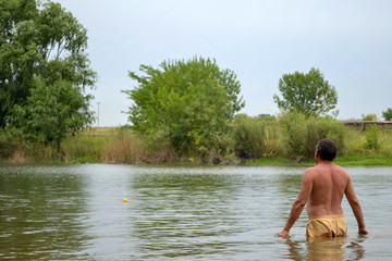 Fototapeta na wymiar Man taking a bath in the river