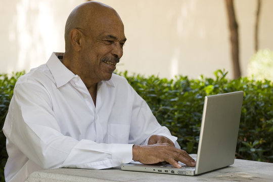 African American senior citizen working on laptop computer