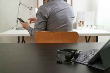 businessman using VOIP headset with digital tablet computer and smart phone,as concept communication and call center or customer service help desk in modern office