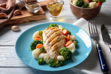 Tasty chicken breast and vegetables on plate