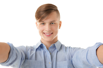Handsome young man taking selfie on white background