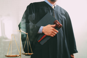 justice and law concept.Male judge in a courtroom with the gavel and balance scale and holy book...