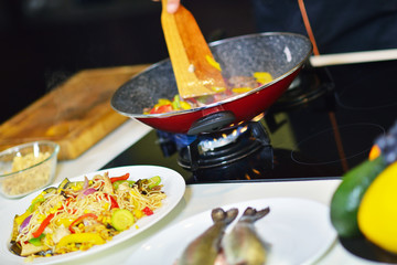Vegetable ragout in pan, on wooden table on bright background