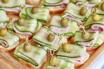 Catering of canape with olives, cucumber and ham