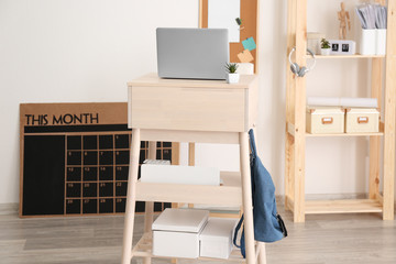 Modern stand-up desk with laptop in room