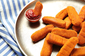 Metal plate with cheese sticks and ketchup sauce, closeup