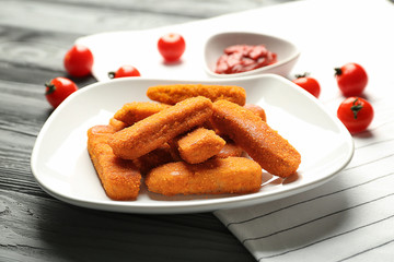 Plate with cheese sticks on wooden background