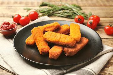 Plate with cheese sticks and ketchup sauce on table