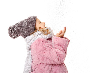 Cute little girl in warm clothes playing with snow on white background