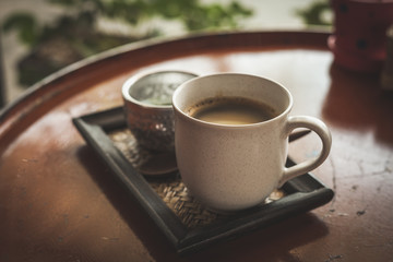 Hot coffee latte or black coffee in the coffee shop, vintage color filter.