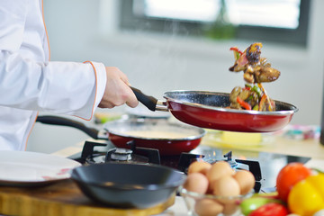mature chef preparing a meal with various vegetables and meat