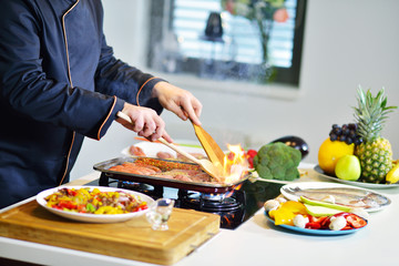 mature chef preparing a meal with various vegetables and meat