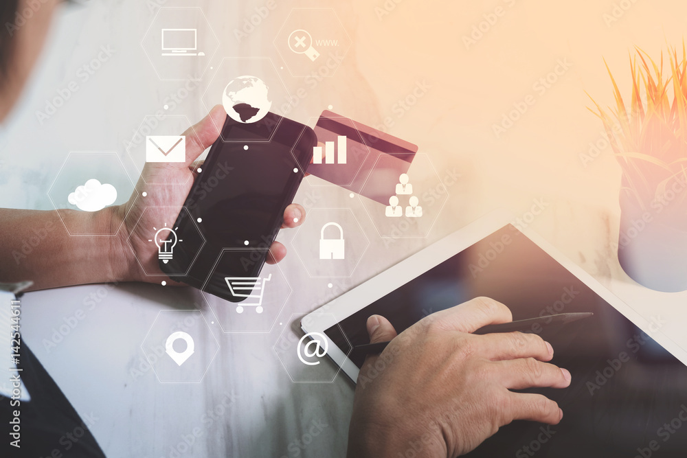 Poster businessman working with smart phone and digital tablet computer and credit card on wooden desk in m