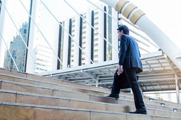 Businessman walking the stairs, modern city background, Businessmen go to goals concept.