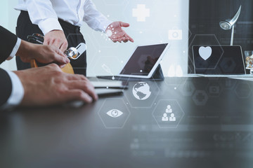 Medical co working concept,Doctor working with smart phone and digital tablet and laptop computer to meeting his team in modern office at hospital with virtual icon diagram
