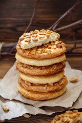 Cookies with a peanut on paper for pastries on wooden table. Selective focus, closeup.