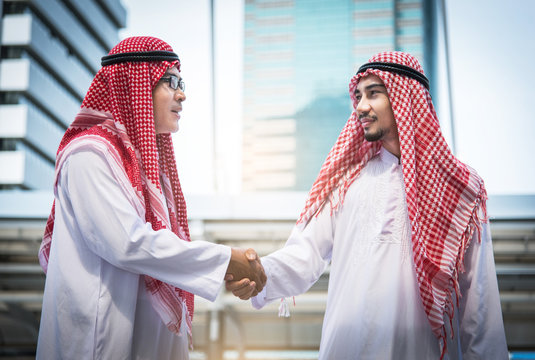 Business success concept. Arab businessman making handshake or holding hand together to agree joint business and partnership.