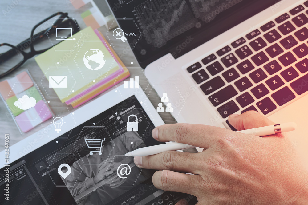 Poster businessman working with laptop computer and digital tablet and book and document on wooden desk in modern office with virtual icons interface