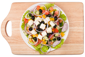 Greek salad in a white plate top view