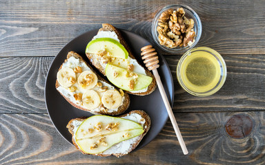 Sandwiches of rye bread and ripe fruit pear banana Apple served on a plate