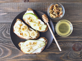 Sandwiches of rye bread and ripe fruit pear banana Apple served on a plate