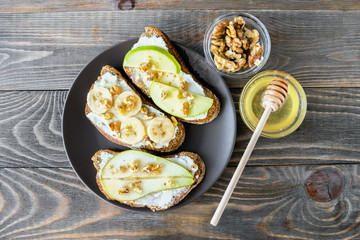 Sandwiches of rye bread and ripe fruit pear banana Apple served on a plate