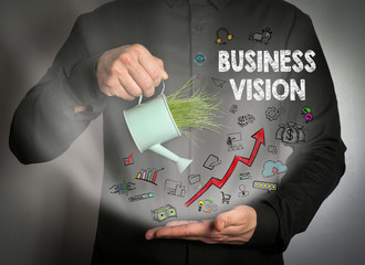 Business Vision. Human hand holding Miniature watering pot with fresh green spring grass. Abstract background for business and development