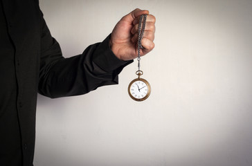 Man holding chain clock on white background.