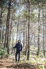Young Man Traveler with backpack relaxing outdoor with pine forest mountains on background, Hike concept.