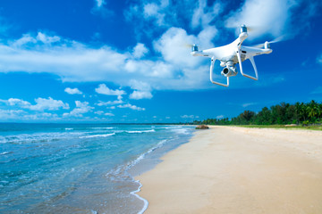 drone flying over sea. white drone hovering in a bright blue sky