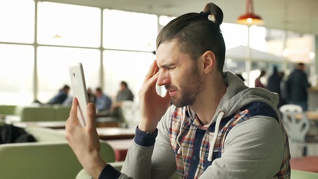 Man looks worried while having a videocall on tablet, steadycam shot
