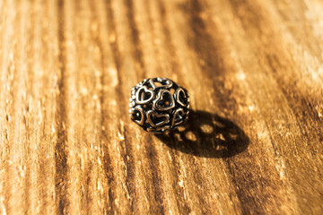 silver bead for bracelet on wooden background